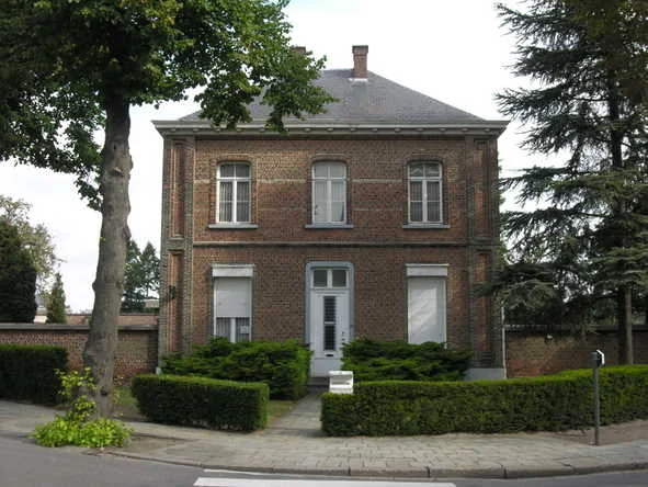 Red-brick two-storey building with a slate roof behind a low hedge, Kleine Nieuwedijkstraat, Mechelen